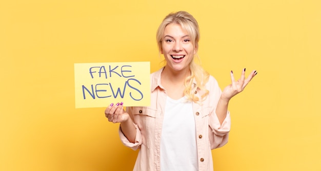 Blonde woman feeling happy, surprised and cheerful, smiling with positive attitude, realizing a solution or idea