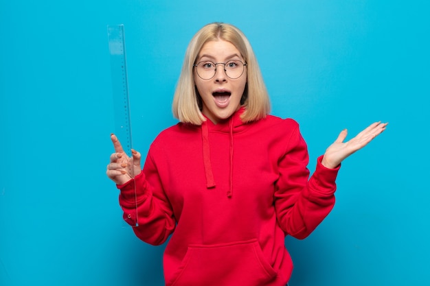 Blonde woman feeling happy, surprised and cheerful, smiling with positive attitude, realizing a solution or idea