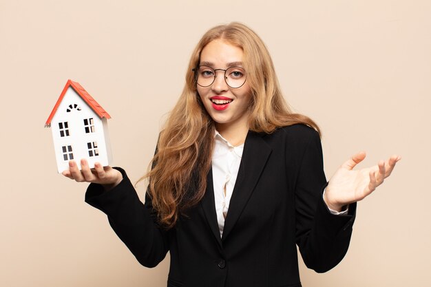 Blonde woman feeling happy, surprised and cheerful, smiling with positive attitude, realizing a solution or idea