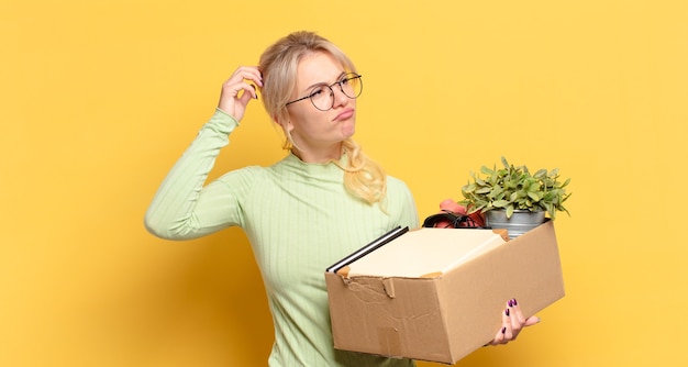 Blonde woman feeling puzzled and confused, scratching head and looking to the side