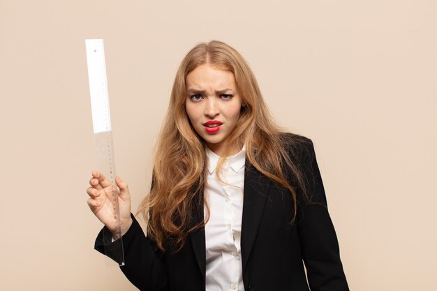 Blonde woman feeling puzzled and confused, stunned expression looking at something unexpected