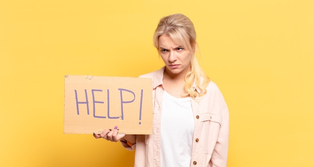 Blonde woman feeling sad, upset or angry and looking to the side with a negative attitude, frowning in disagreement