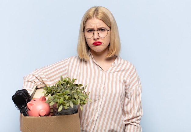 Blonde woman feeling sad and whiney with an unhappy look, crying with a negative and frustrated attitude