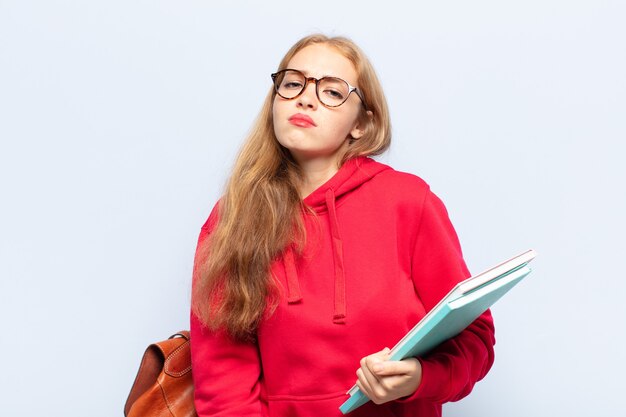 Blonde woman feeling sad and whiney with an unhappy look, crying with a negative and frustrated attitude