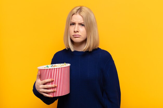 Blonde woman feeling sad and whiney with an unhappy look, crying with a negative and frustrated attitude