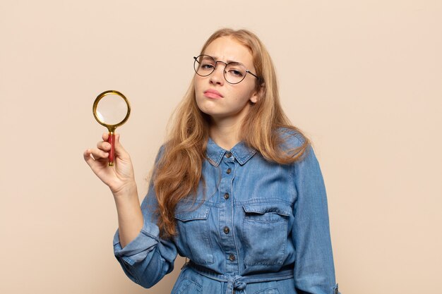 Blonde woman feeling sad and whiney with an unhappy look