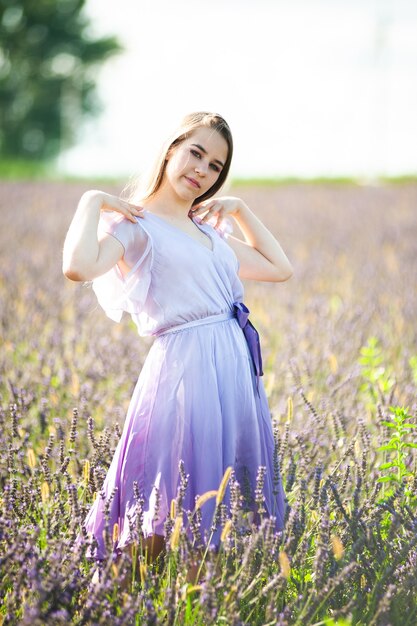 Blonde woman on the garden field in the summer