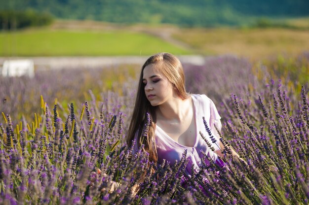 Blonde woman on the garden field in the summer