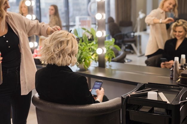 Foto donna bionda che si fa fare i capelli