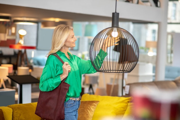 Blonde woman in a green blouse looking at the cage