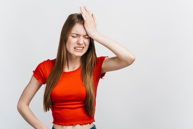 Foto donna bionda che ha mal di testa