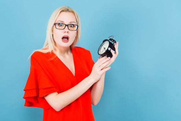 Blonde woman holding alarm clock