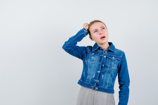 The blonde woman is thinking by putting her hand on head  on white background