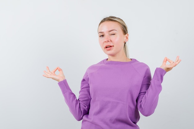 ブロンドの女性は白い背景でウインクしています