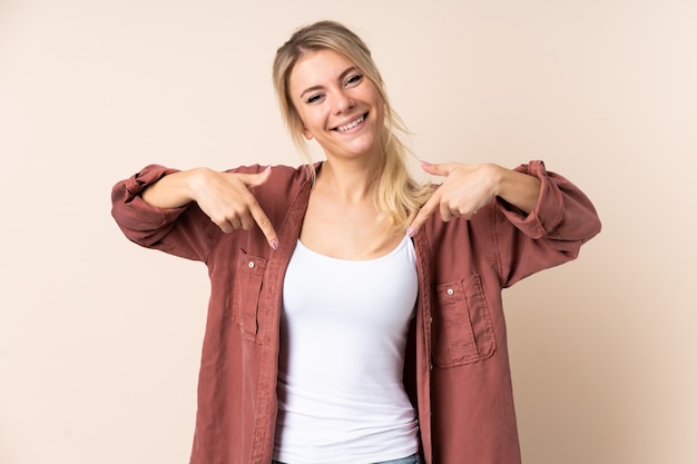 Blonde woman over isolated background proud and self-satisfied