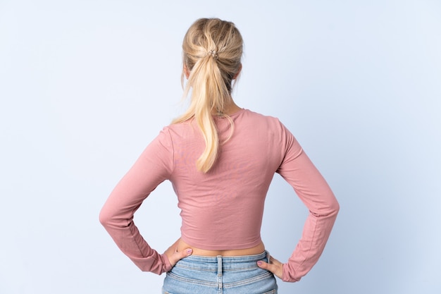 Photo blonde woman over isolated blue in back position