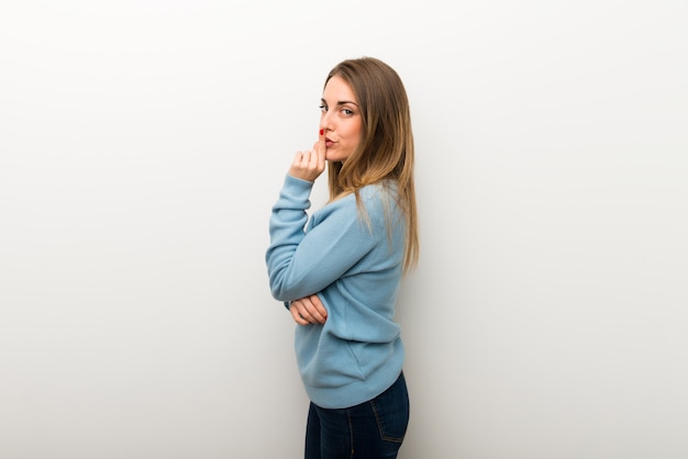 Photo blonde woman on isolated white background showing a sign of closing mouth and silence gesture