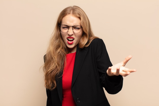 Blonde woman looking angry, annoyed and frustrated screaming wtf or whatâs wrong with you