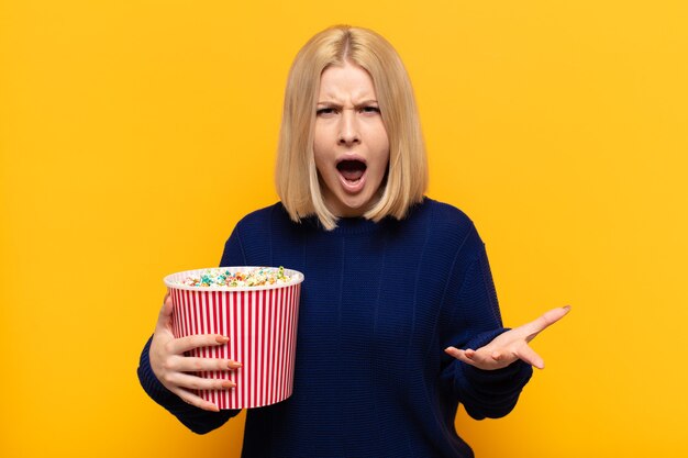 Blonde woman looking angry, annoyed and frustrated screaming wtf