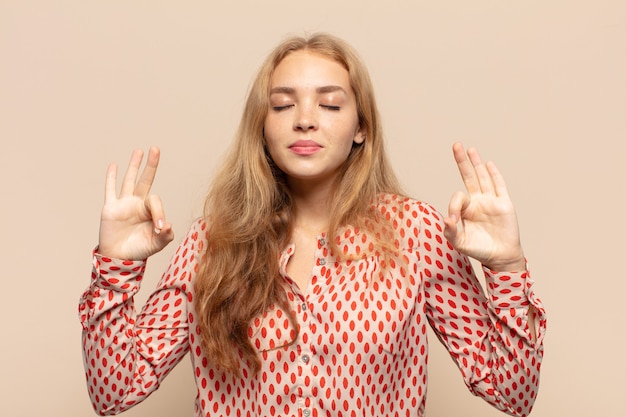 Photo blonde woman looking concentrated and meditating, feeling satisfied and relaxed, thinking or making a choice