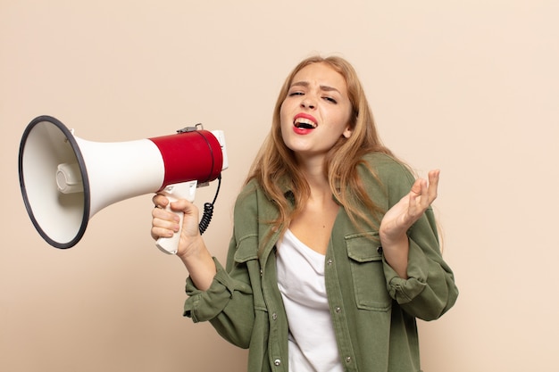 Blonde woman looking desperate and frustrated, stressed, unhappy and annoyed, shouting and screaming