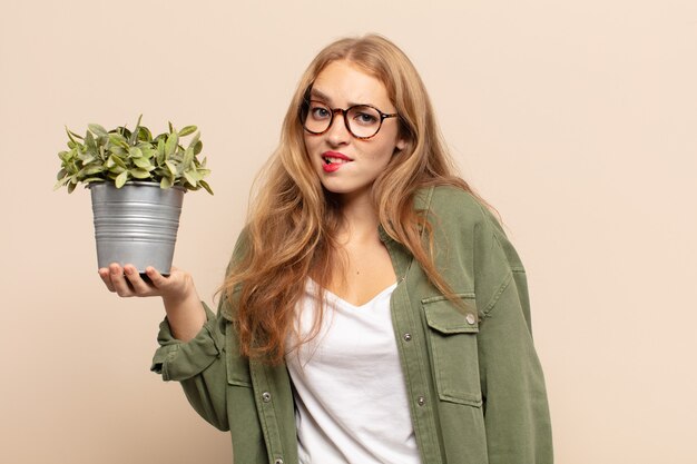 Blonde woman looking puzzled and confused, biting lip with a nervous gesture, not knowing the answer to the problem