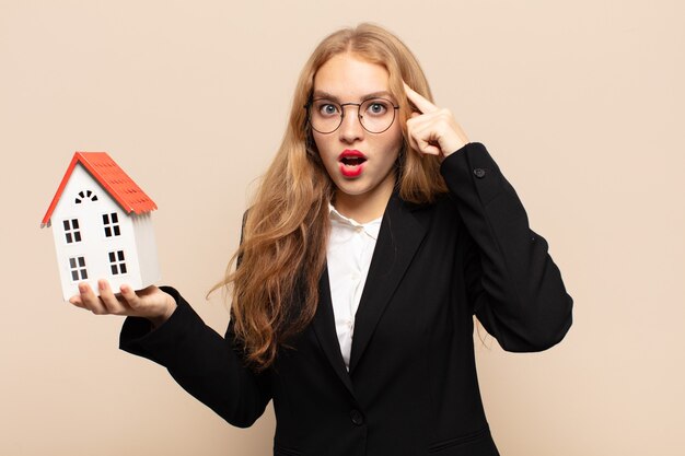 blonde woman looking surprised, open-mouthed, shocked, realizing a new thought, idea or concept