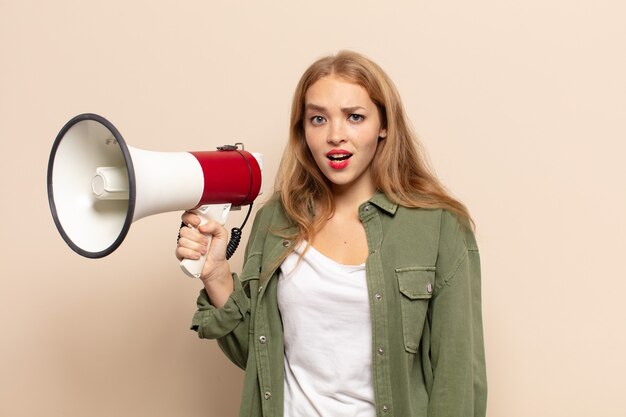 Blonde woman looking very shocked or surprised, staring with open mouth saying wow