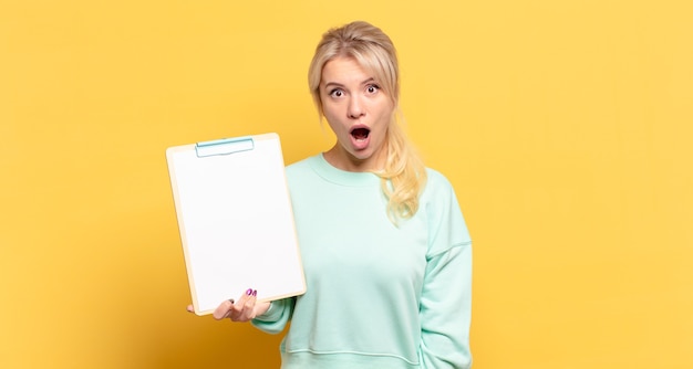 Blonde woman looking very shocked or surprised, staring with open mouth saying wow