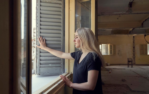 Photo blonde woman looking at the window