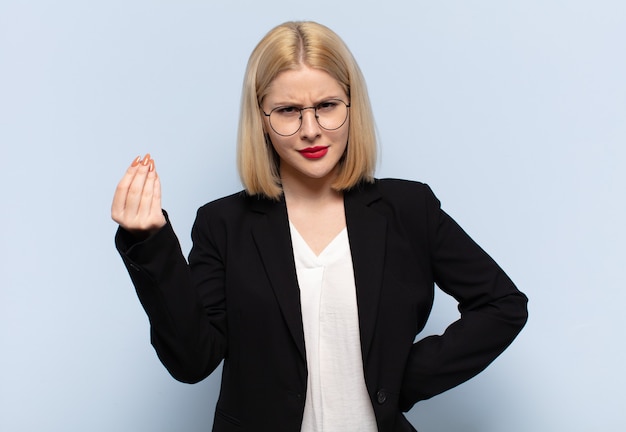 Blonde woman making capice or money gesture, telling you to pay your debts!