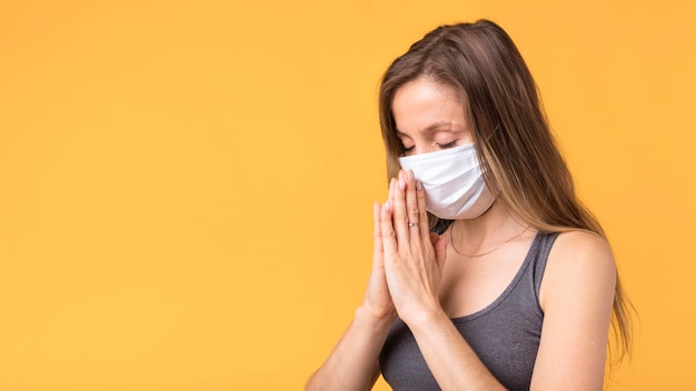 Blonde woman meditating with a face mask on with copy space