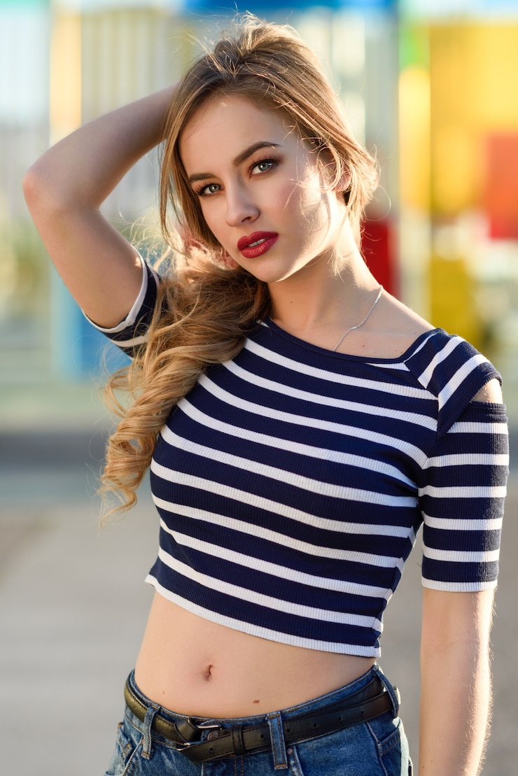 Photo blonde woman, model of fashion, sitting in urban background.