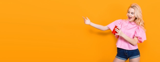 Blonde woman in pink blouse with red cup