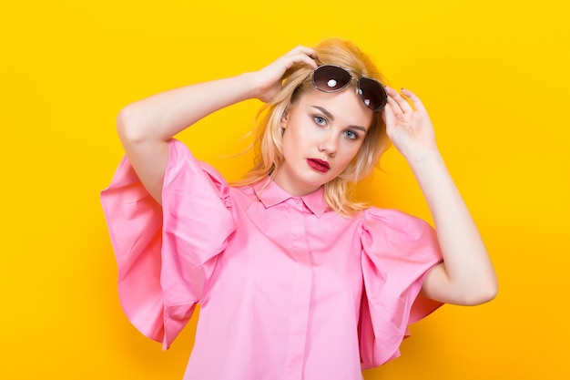 Blonde woman in pink blouse with sunglasses