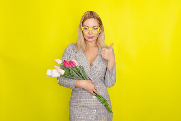 Blonde woman in plaid dress holding tulips bouquet