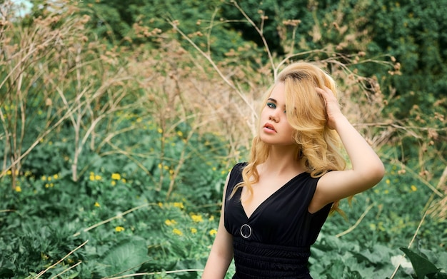 A blonde woman posing in nature