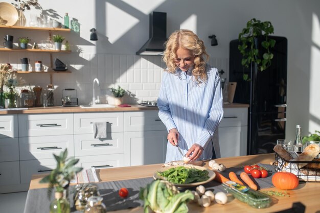 Foto donna bionda che prepara il cibo in cucina