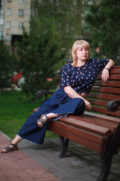 Blonde woman sitting on a bench