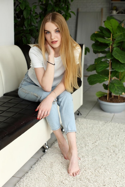 Photo blonde woman sitting on modern sofa