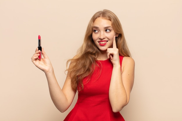 Blonde woman smiling happily and daydreaming or doubting, looking to the side