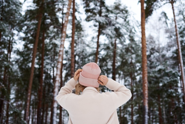 Blonde woman standing backwards and watching magic lake in mountainous country landscape.