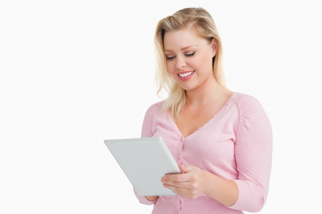 Blonde woman standing while using her touchscreen