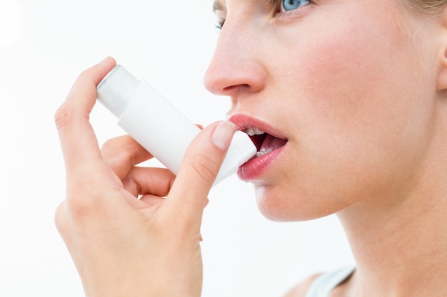 Blonde woman taking her inhaler