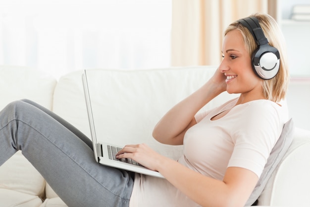 Blonde woman watching a movie with her laptop