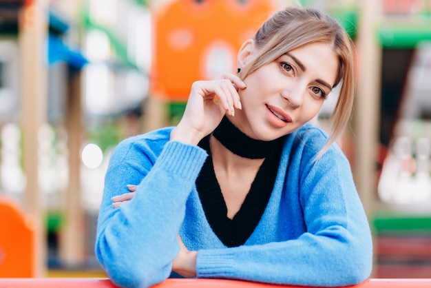 Blonde woman wearing in blue sweater standing