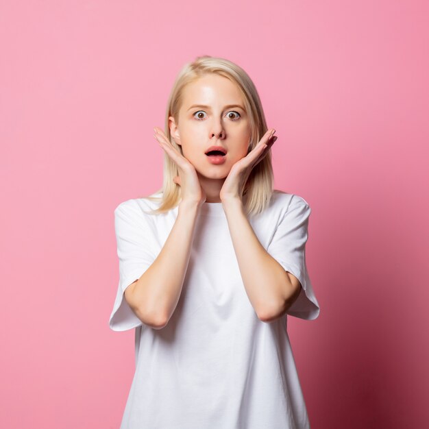 Blonde woman in white tshirt on pink