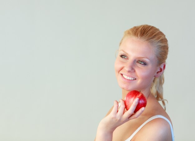 Donna bionda con una mela con focus sulla donna