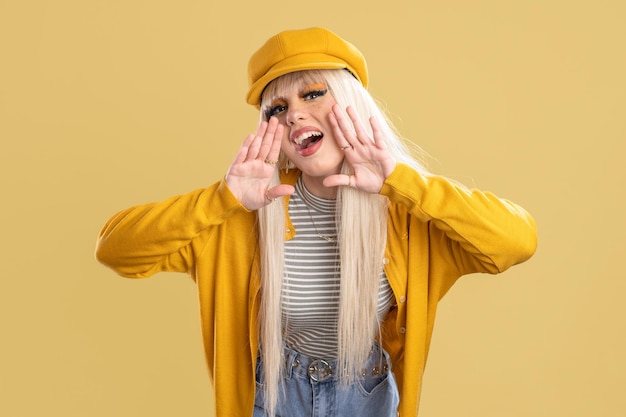 Blonde woman with cap and yellow jacket With her hands on her mouth sketching