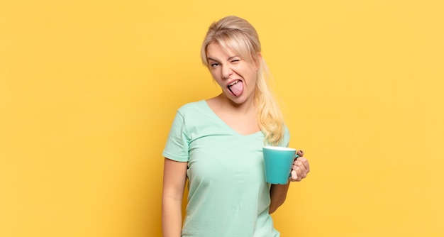 Blonde woman with cheerful, carefree, rebellious attitude, joking and sticking tongue out, having fun